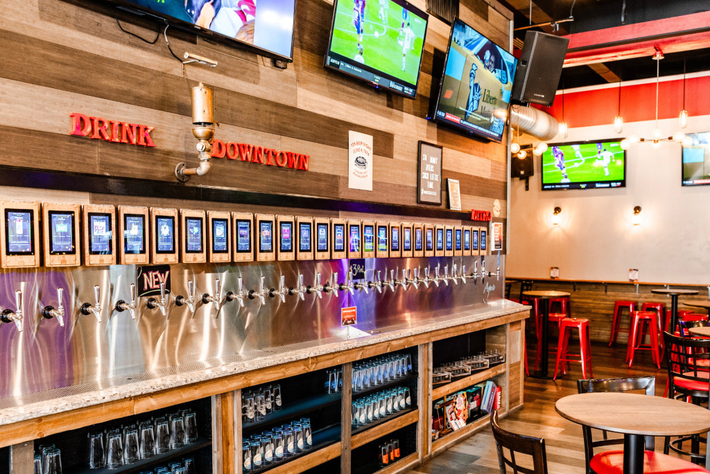 Chelsea FC game day at Whistle Taproom with fans watching on 18 TVs, enjoying food and beer.