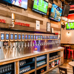Chelsea FC game day at Whistle Taproom with fans watching on 18 TVs, enjoying food and beer.
