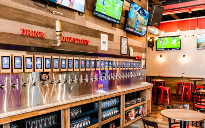 Chelsea FC game day at Whistle Taproom with fans watching on 18 TVs, enjoying food and beer.