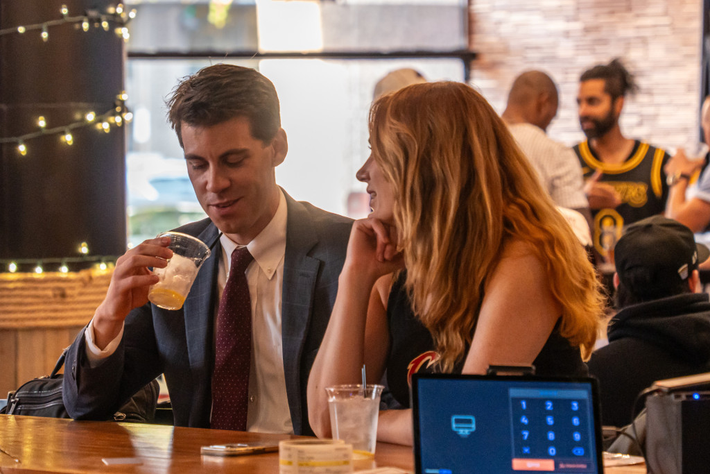 A lively happy hour crowd enjoying drinks and food at Whistle Taproom in Cleveland.