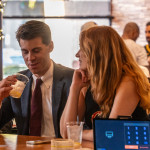 A lively happy hour crowd enjoying drinks and food at Whistle Taproom in Cleveland.