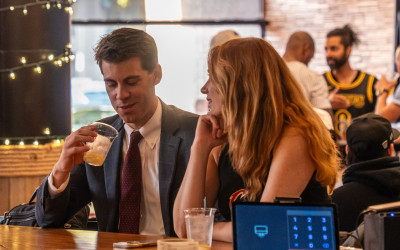 A lively happy hour crowd enjoying drinks and food at Whistle Taproom in Cleveland.